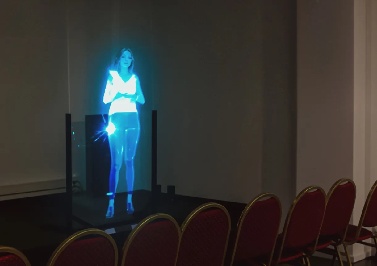 Presentación holográfica de persona en escenario con sillas de audiencia